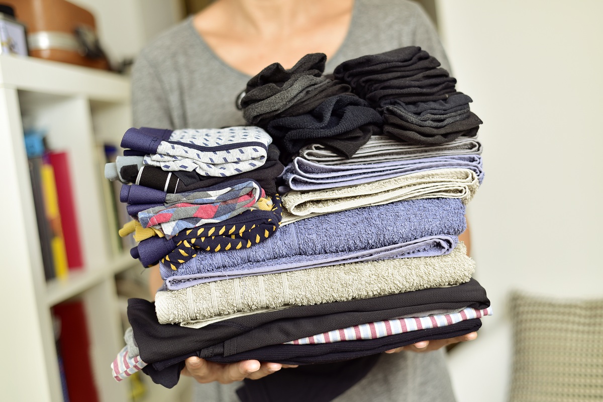 woman holding stack of clothes