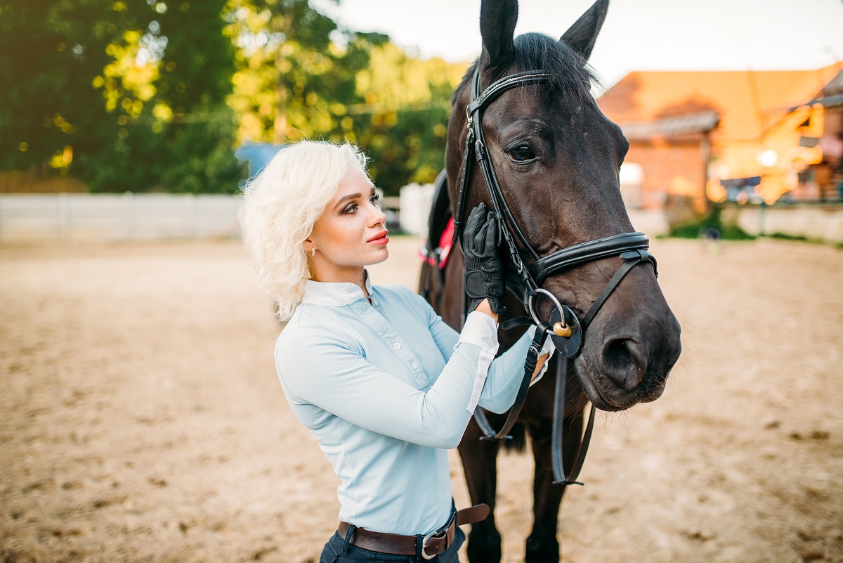 Female rider hugs her horse, horseback riding