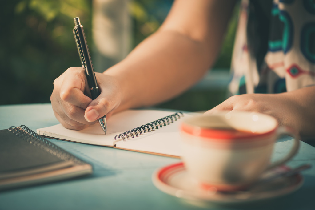 person writing on a notebook