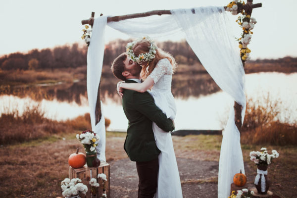 groom lifting up bride in her white dress while kissing