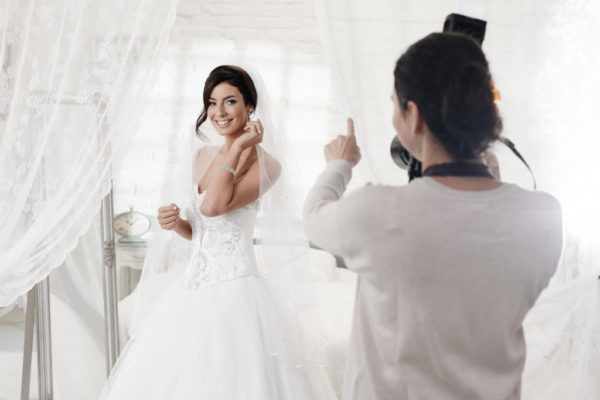bride taking photos in her wedding dress