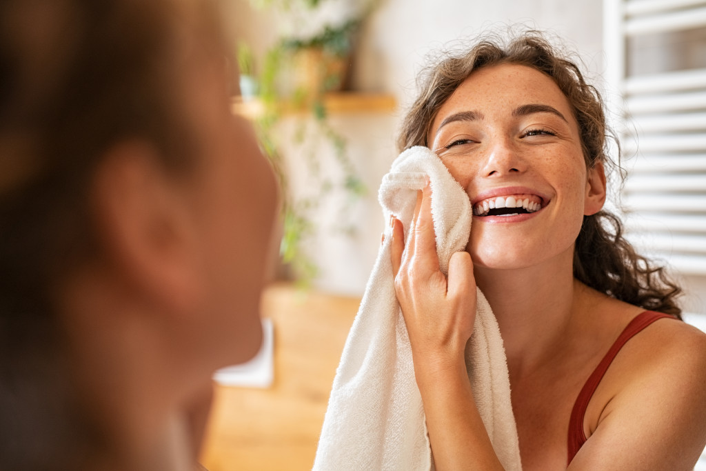 woman cleaning and drying skin with napkin