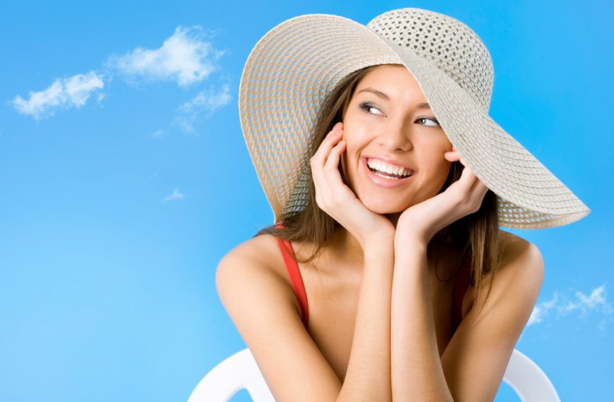 A beautiful woman wearing a large hat on a sunny day