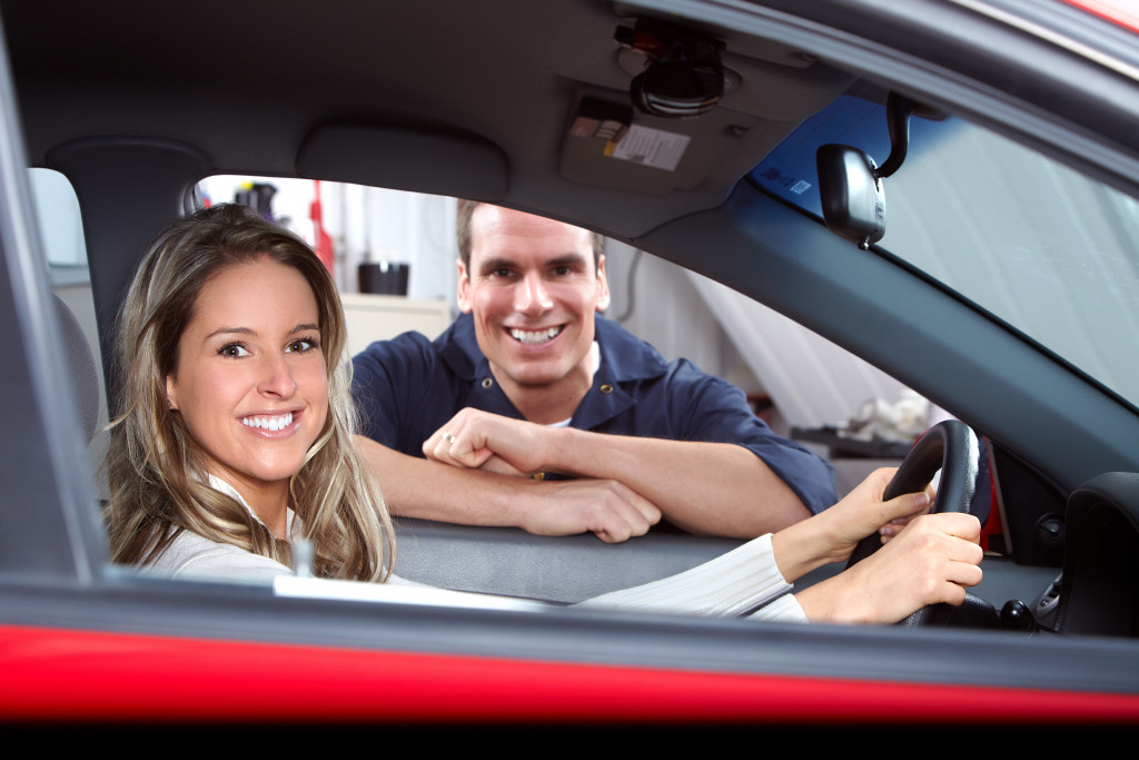 a woman with a car mechanic after service