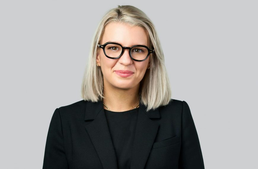 professional headshot of a blonde woman wearing all black and eyeglasses